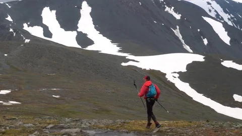 Trail runner with a little backpack and poles climbing a stone trail. Stock Footage 121132871