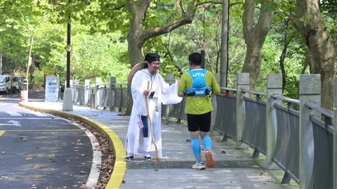 Trail Runner Shaking Hands with Costume Character on Roadside, Lushan Stock Footage 346715786