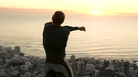 Trail runner stretching overlooking the city of capetown in golden light 4k Stock Footage 338228188