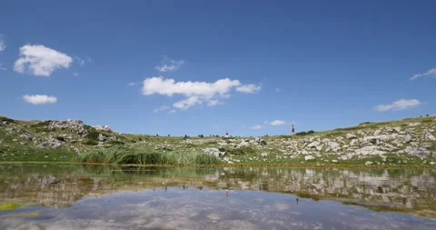 Trail running athletes running close to the mountain lake. Their reflection on t Stock Footage 139986708