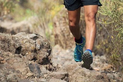 Trail running man on mountain path Foto stock