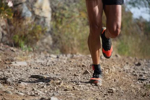 Trail running man on mountain path Stock Photos