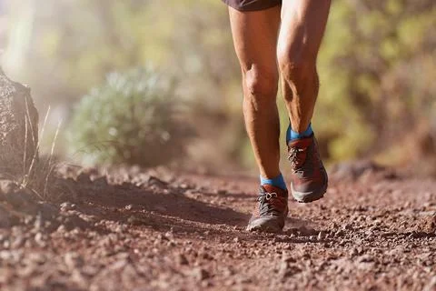 Trail running man on mountain path Stock Photos