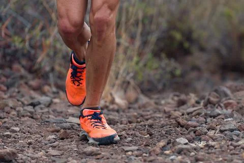 Trail running man on mountain path Stock Photos