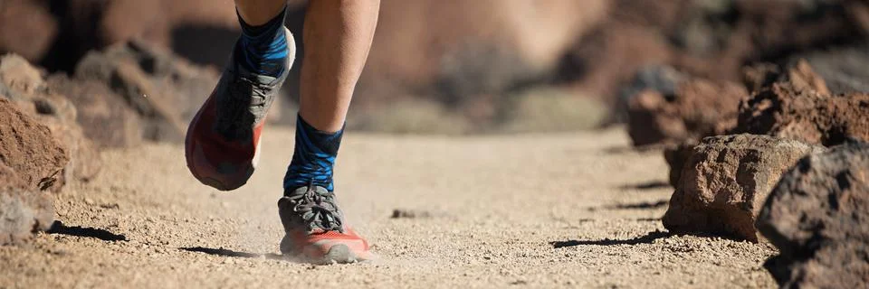 Trail running man on mountain path Stock Photos