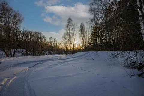 The trail of a snowmobile in the impassable snows of winter nature Stock Photos