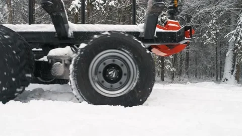 A trailer with a crane passes by on the road in a winter snow-covered forest Stock Footage 169548676
