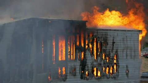 Trailer home on fire. Slow motion. Large house fire ablaze with large flames and Stock Footage 229816798