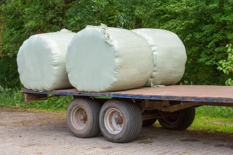 Trailer with plasticized hay rolls Stock Photos