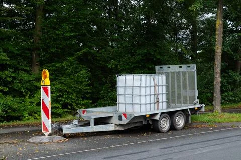 Trailer with storage containers positioned alongside roadway Stock Photos