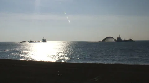 Trailing suction hopper dredger rainbowing near seawall Hondsbossche Zeewering Stock Footage 36867050