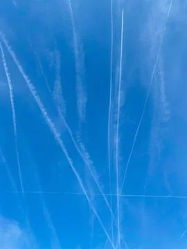 Trails left behind by multiple aeroplanes flying over Frankfurt, Germany Stock Photos
