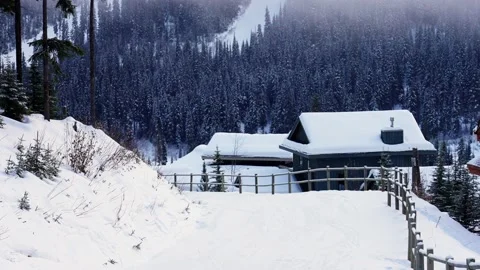 Trails in the snow leading toward small village on a cold winter evening 動画素材 145333028
