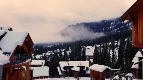 Trails in the snow leading toward small village on a cold winter evening Vídeo Stock 145333110