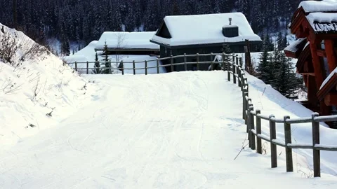 Trails in the snow leading toward small village on a cold winter evening 動画素材 145333292
