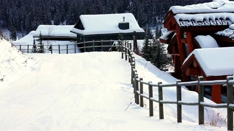 Trails in the snow leading toward small village on a cold winter evening Vídeos de archivo 145333505