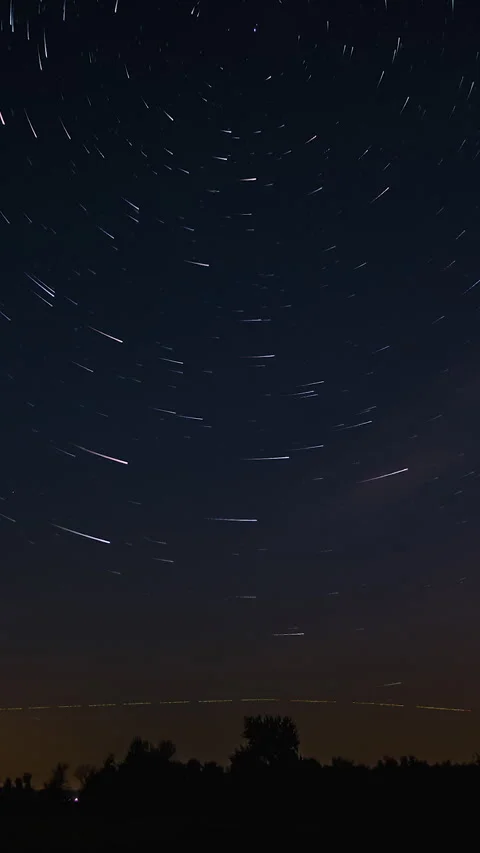 Trails of stars in the night sky with comet trails above the horizon Stock Footage 335154652