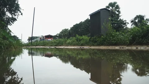 Train and reflection pass by next to a large puddle in the rain Stock Footage 95620872