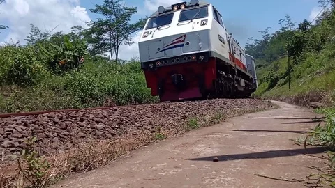 Train approaching and passing by on track in Indonesia East Java Video stock 89641801
