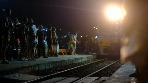 Train is approaching in Ayutthaya while tourists are waiting during night Stock Footage 102629278