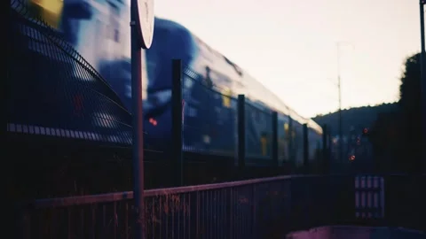 Train approaching in low light during sunset, with headlights illuminating the Stock-Footage 323055501