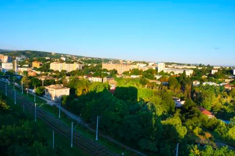 Train approaching on tracks along roads &amp; green vegetation, fly overTrain app Stock Photos