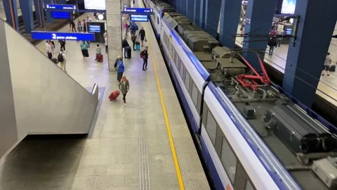 Train arrives on platform of railway train station and many people get on the Stock Footage 200778010