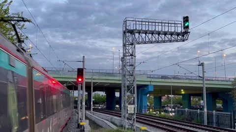 The train arrives at the twilight platform under the bridge - stock video Stock Footage 240342812
