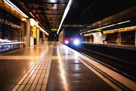 Train arriving at an empty subway train station blurred Stock Photos