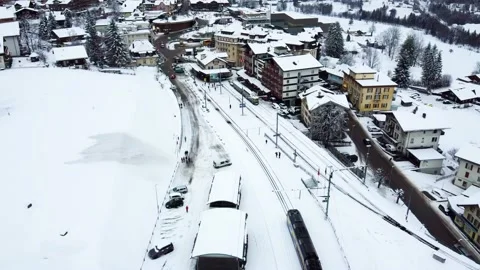 Train is arriving to Grindelwald Train Station in Switzerland aerial drone video Stock Footage 232224209