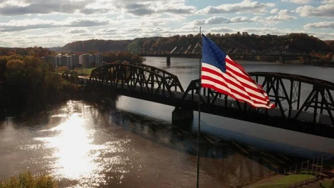 Train on Bridge Above River with American Flag Stock Footage 99002534