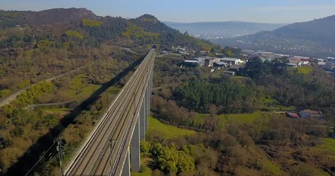TRAIN BRIDGE IN A GREEN VALLEY WITH FACTORIES, HOUSES AND THE CITY OF OURENSE Stock Footage 103288518