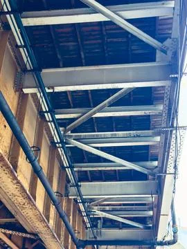 A train bridge structure is visible from below, showing metal beams and woode Stock Photos