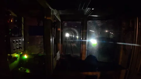 A train cabin traveling through a dark underground railway tunnel at night 库存影片 333616706