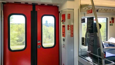 Train carriage interior featuring bright red sliding doors and metal han.. Stock Photos
