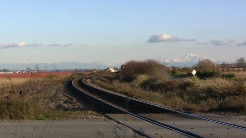 Train coming around bend with fall/winter landscape and mountain in b/g Stock Footage 98002577