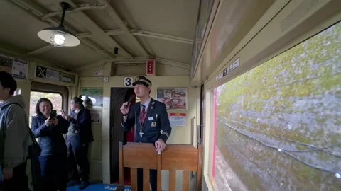 Train conductor entertaining passengers on a vintage scenic train ride Vídeos de archivo 333621630