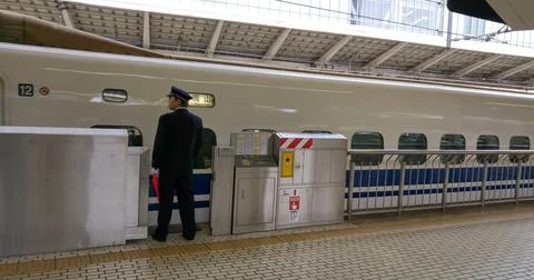 Train Conductor Preparing for Train Departure on the Tokyo Station Platform Foto stock