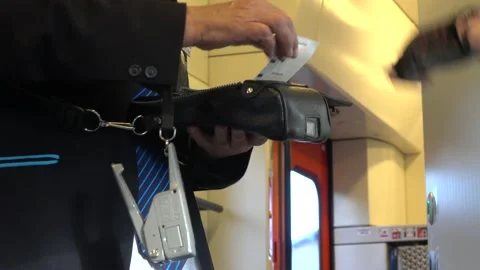 The train conductor is printing ticket and receive money from the passenger Stock Footage 158506681