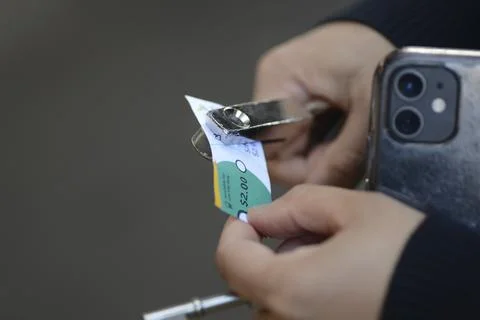 A train conductor punches a train ticket at the Wellington train station Stock Photos