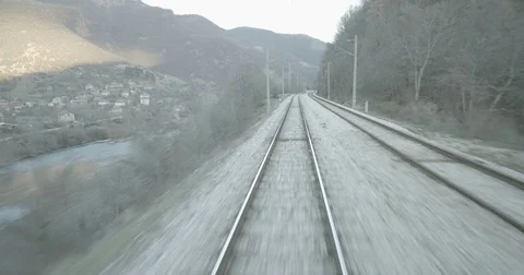 Train crosses a river passage in mountain canyon Stock Footage 83886034