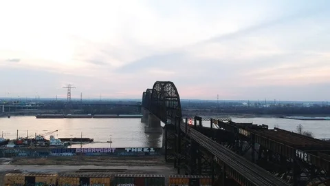 Train crossing beneath large steel bridge Stock Footage 104872180
