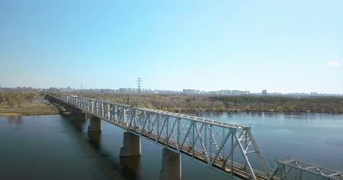 A train crossing a bridge over a body of water Vídeos de archivo 128636037