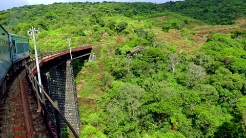 Train crossing bridge through amazing highlands landscape. Sri Lanka Stock Footage 75769024