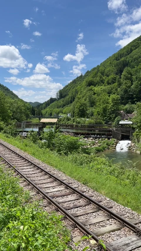 Train crossing next to a water mill Stock Footage 276782716