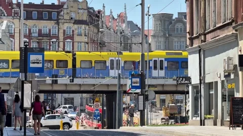 Train Crossing a Railway Bridge Above a City Street in Katowice, Poland Stock Footage 345122343