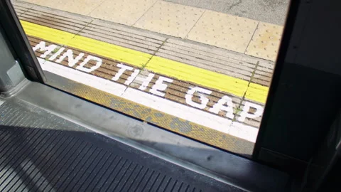 Train door view with “Mind the Gap” warning on the platform and closing doors Stock-Footage 319724723