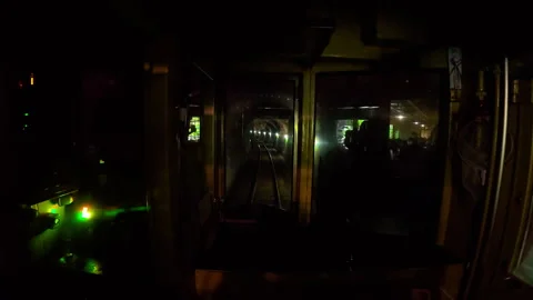A train driver's cabin, moving from a dark tunnel into the daylight Stock Footage 333843908