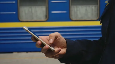The train driver's hand is a mobile phone against a blue wagon Stock Footage 111395219
