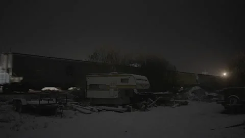 Train driving by behind snow covered camper trailer Stock Footage 225415899